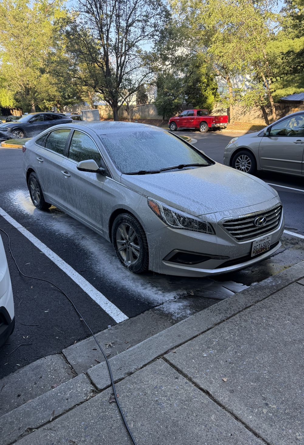 A silver Hyundai Sonata covered in foam in a parking lot